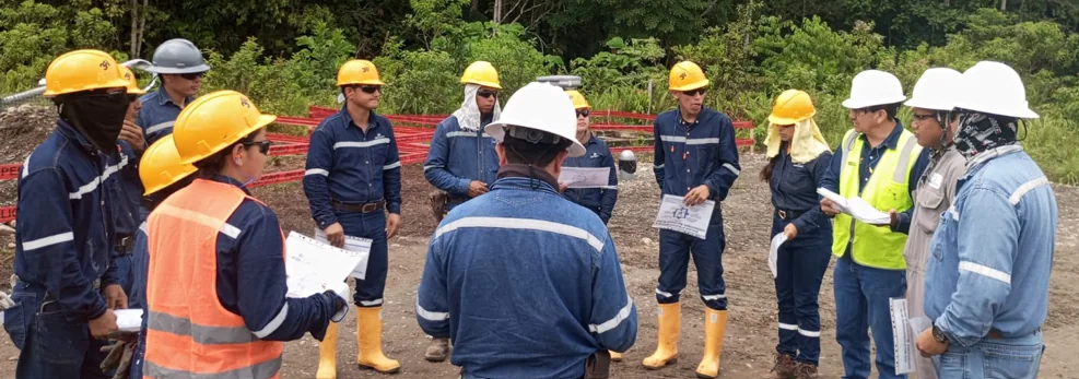 Facilitador conversa con trabajadores equipados para la operación